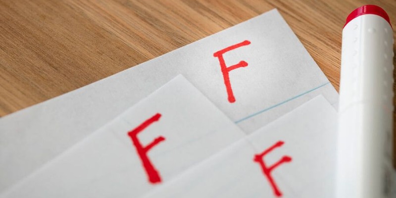 Pieces of paper with a failing grade of 'F' at the top.
