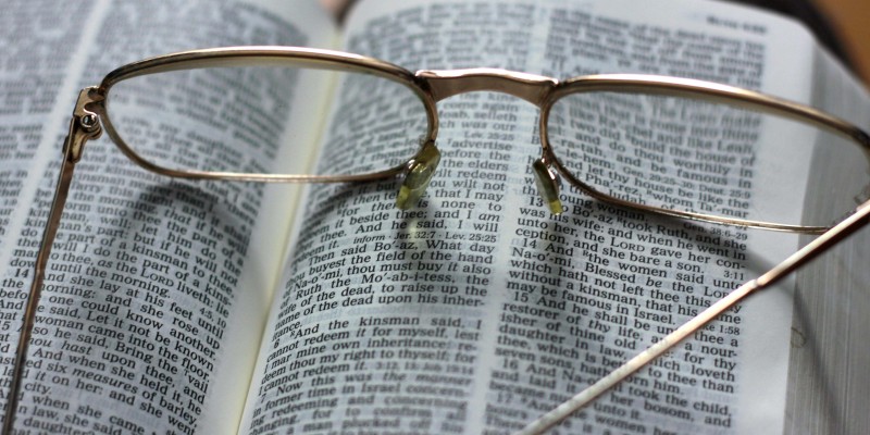 Open Bible with glasses on top