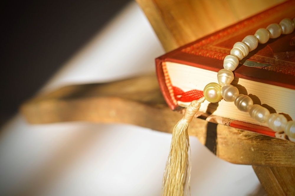 Beads and Koran on edge of table