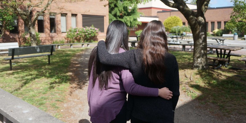 Two women hold each other.