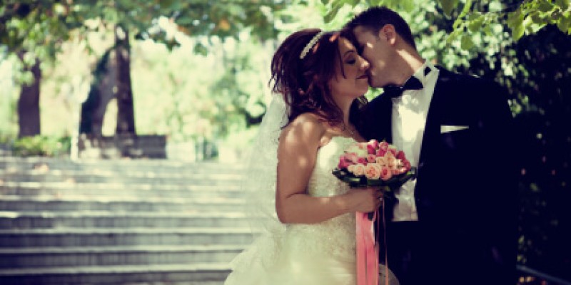 A happy couple being wed under greenery