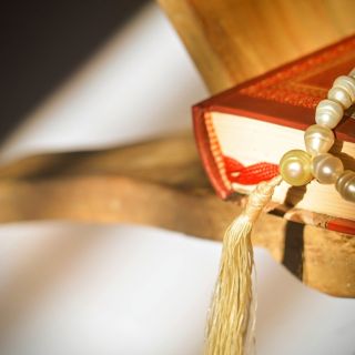 Beads and Koran on edge of table