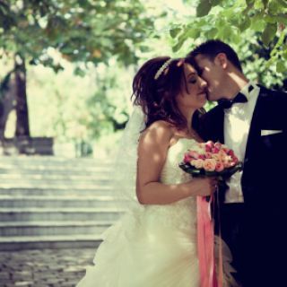 A happy couple being wed under greenery